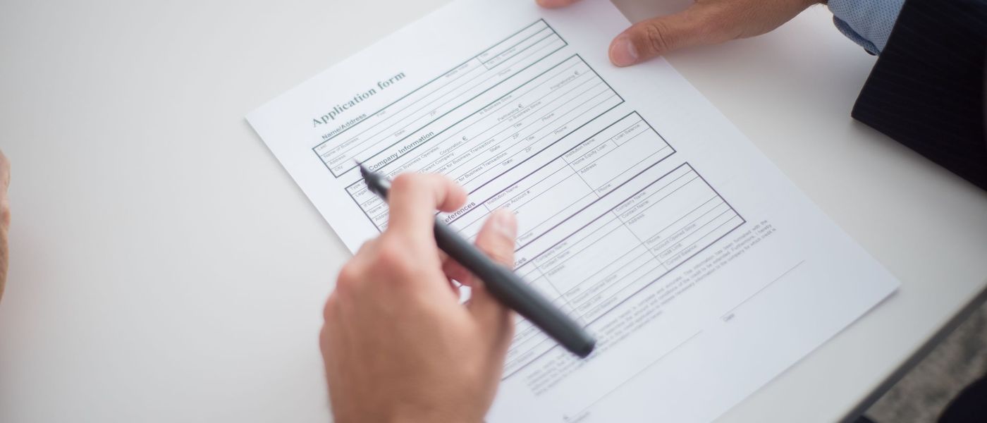 A consultant and a client going through an application form together at a desk